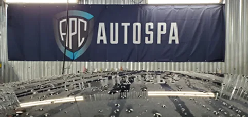APC Auto Spa banner above a water-beaded vehicle in the shop
